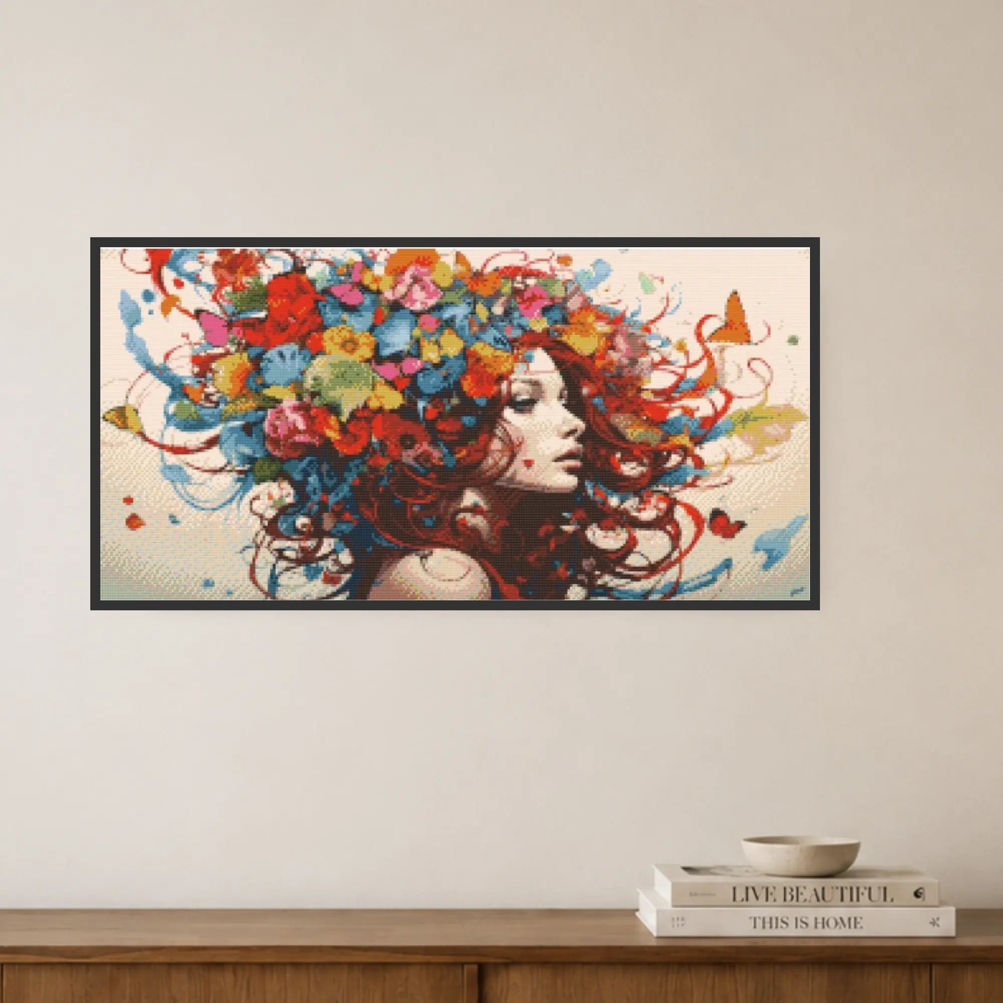 Framed artwork of a woman with colorful hair and flowers on a wall above a wooden shelf. Free as a Butterfly Diamond Painting Kit by Nordik Atelier