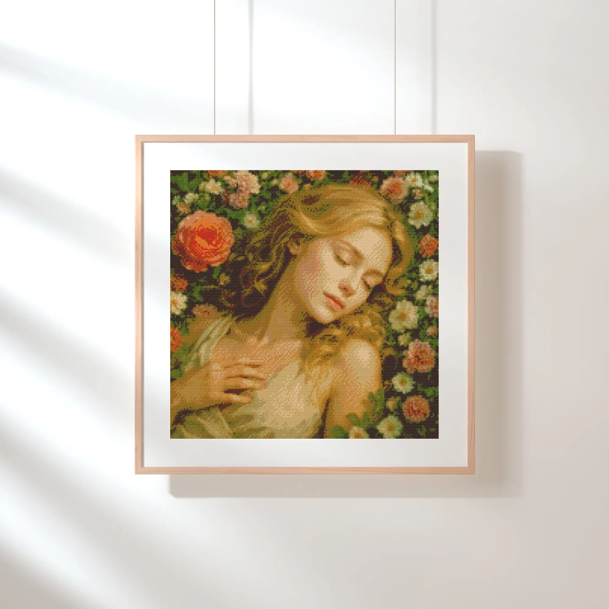 Framed artwork of a woman surrounded by flowers on a white wall Sleeping Beauty in Rose Garden | Diamond Painting Kit